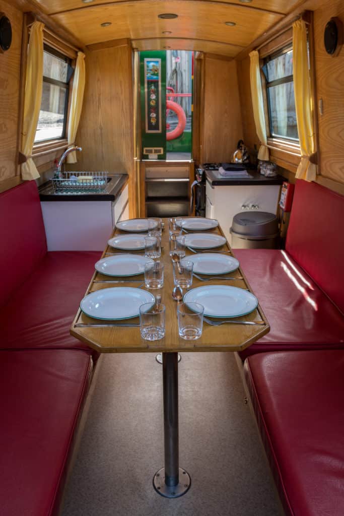 Inside a Snaygill day boat — the table laid for eight, with bench seating and the galley behind